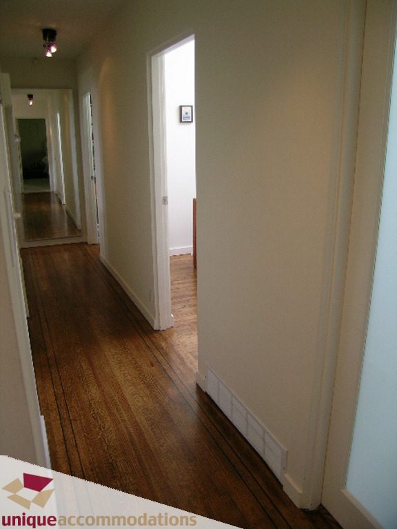 Furnished hallway with hardwood floors and white walls. - 68 Bonnymuir Drive, West Vancouver