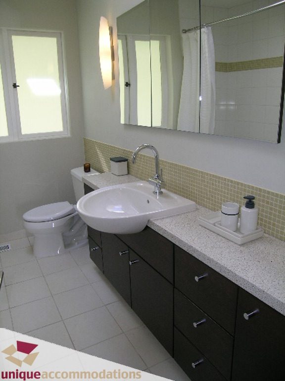 Bathroom with white countertop, dark cabinets, and wall-mounted sink. - 68 Bonnymuir Drive, West Vancouver