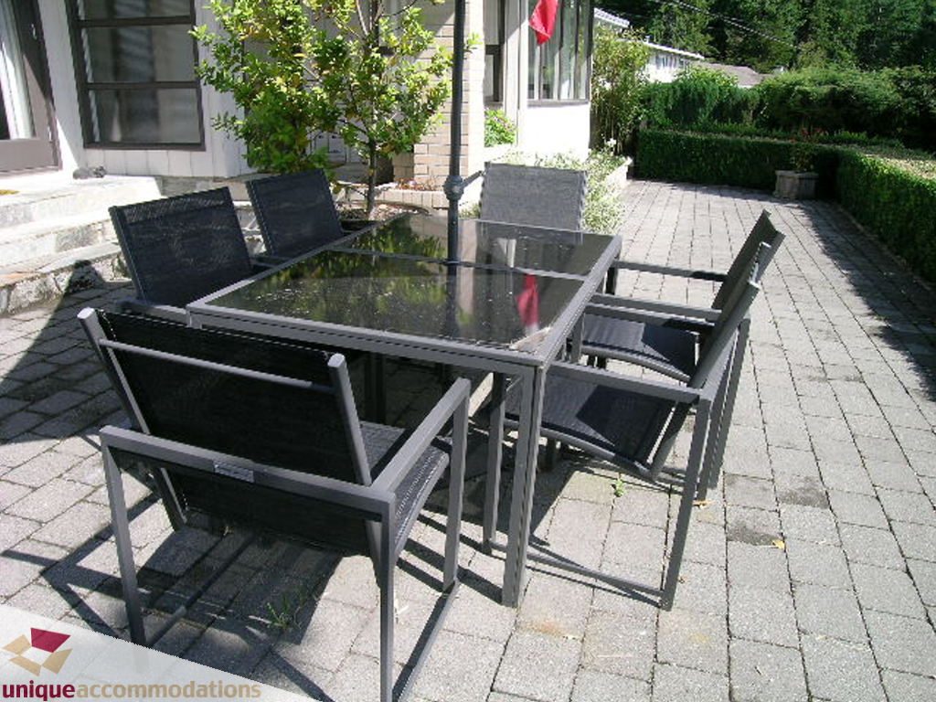 Furnished patio with outdoor dining set and potted plants. - 68 Bonnymuir Drive, West Vancouver