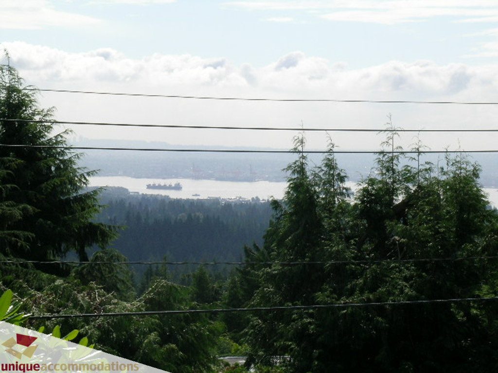 Furnished living room with a stunning city view and lush greenery. - 68 Bonnymuir Drive, West Vancouver