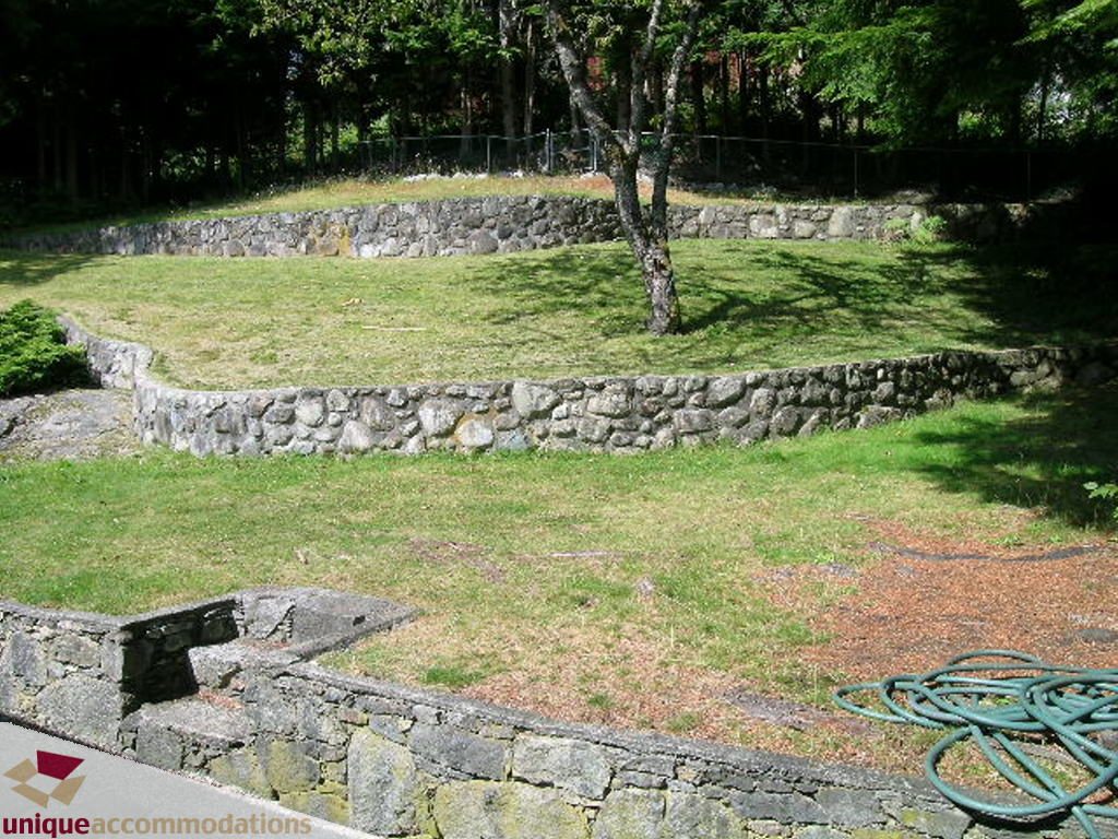 Lush garden with stone terraces and a tree providing shade. - 68 Bonnymuir Drive, West Vancouver