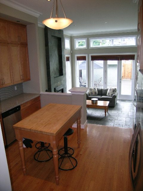 Bright kitchen with granite countertops, hardwood floors, and a view of the living area. - 3670 Point Grey Road, Vancouver West Side