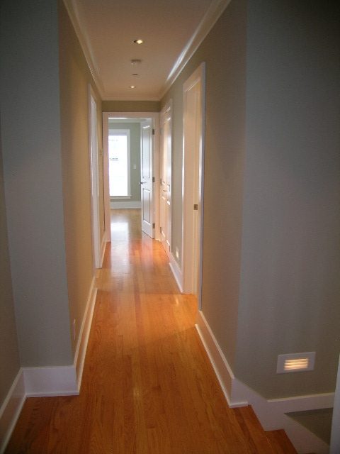 Bright hallway with hardwood floors and white trim, leading to a well-lit room at the end. - 3670 Point Grey Road, Vancouver West Side