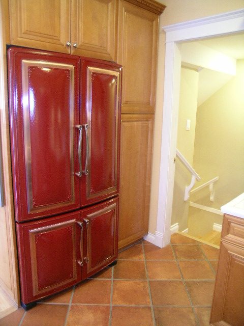Bright kitchen with red refrigerator, wooden cabinets, and terracotta tile flooring. - 3077 West 2nd Avenue, Vancouver West Side