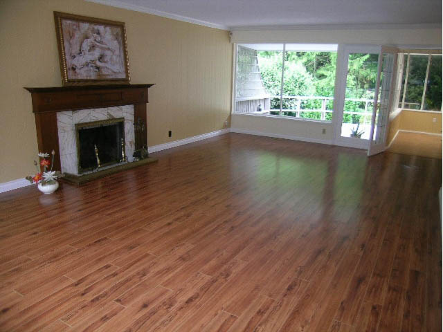 Bright living room with hardwood floors and large windows, showcasing a serene outdoor view. - 5725 Cranley Drive, West Vancouver