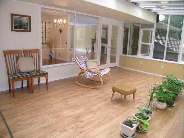 Bright sunroom with hardwood floors, potted plants, and sliding glass doors leading to a deck. - 5725 Cranley Drive, West Vancouver