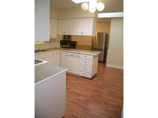 Bright kitchen with white cabinets, granite countertops, and hardwood floors. - 5725 Cranley Drive, West Vancouver
