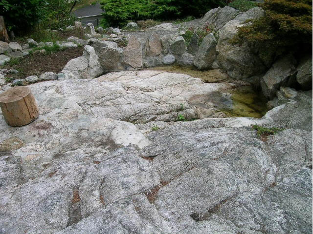 Rocky outdoor area with natural stone formations and a small water feature. - 5725 Cranley Drive, West Vancouver