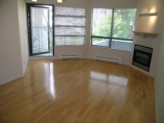 Bright living room with hardwood floors, city view, and modern fireplace. - 305 - 2228 Marstrand Avenue, Vancouver West Side