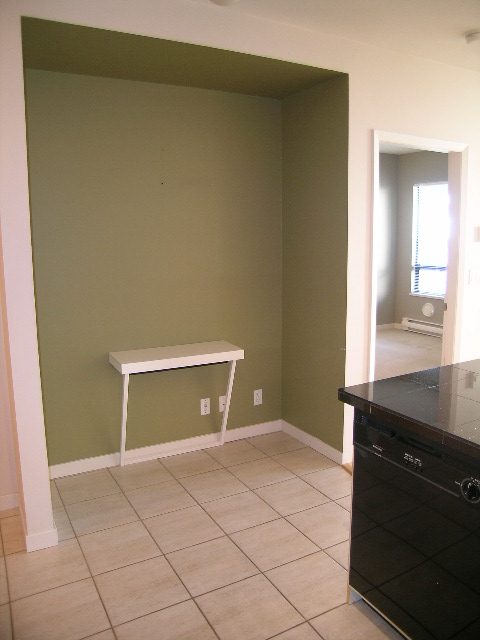 Bright kitchen with olive green accent wall, black countertops, and white tile flooring. - 305 - 2228 Marstrand Avenue, Vancouver West Side
