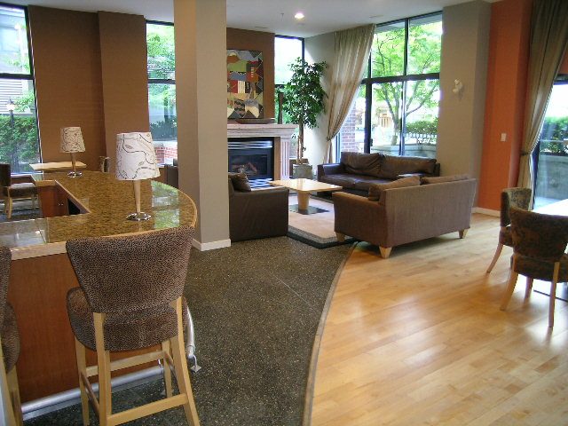 Spacious living room with hardwood floors, large windows, and a cozy fireplace. - 305 - 2228 Marstrand Avenue, Vancouver West Side