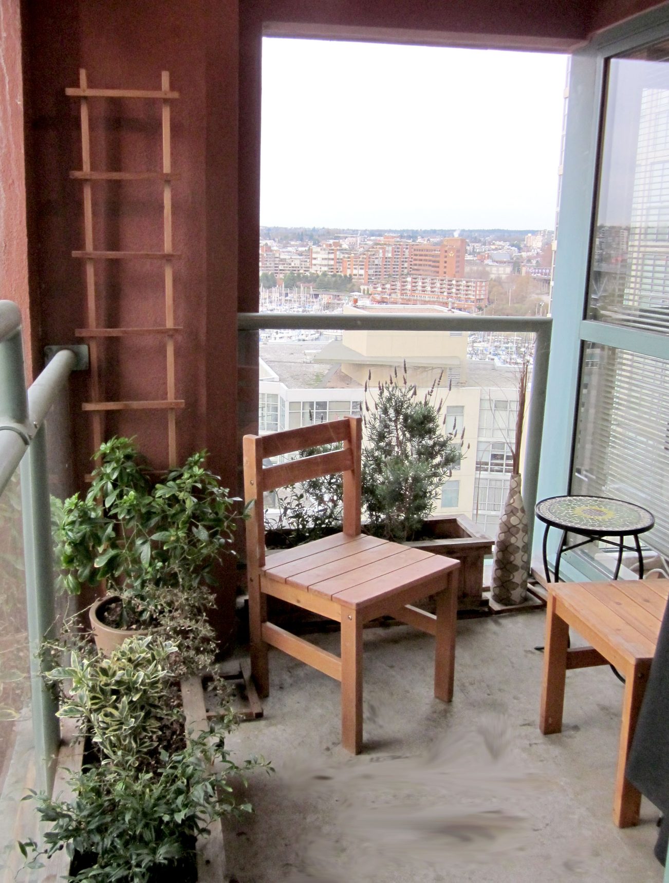 Furnished balcony with wooden furniture, city view, and potted plants. - 1403 - 907 Beach Avenue, Vancouver Downtown