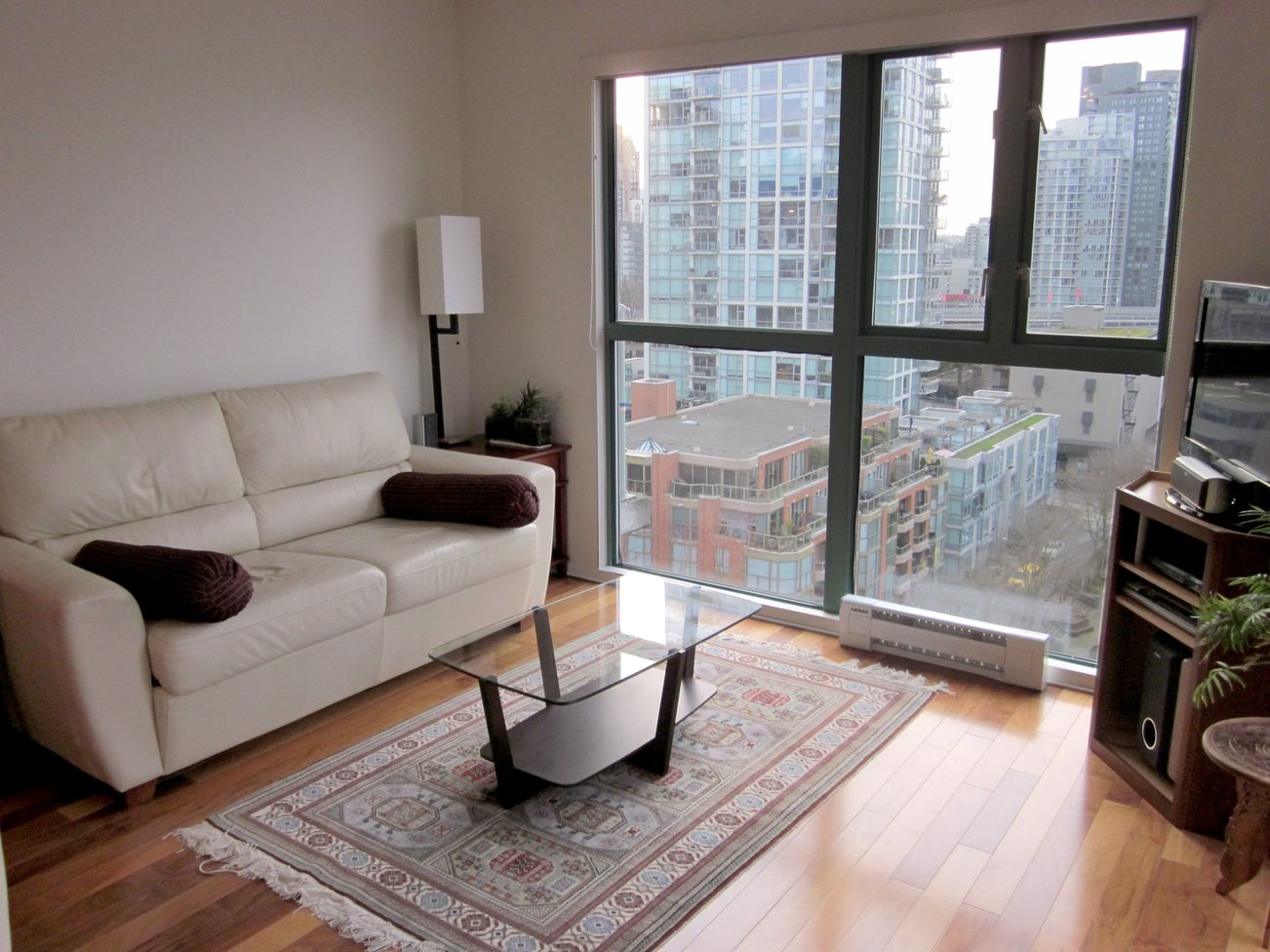Bright living room with hardwood floors, city view, and modern furniture. - 1403 - 907 Beach Avenue, Vancouver Downtown