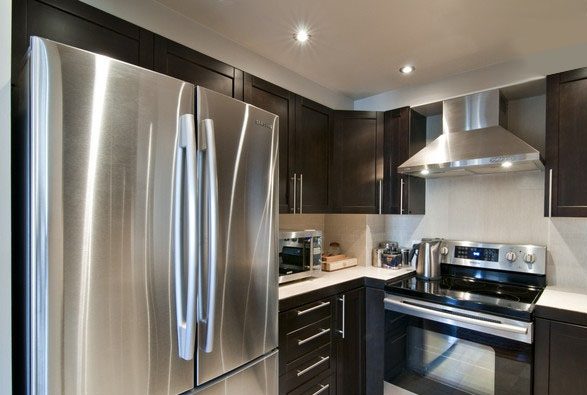 Bright kitchen with stainless steel appliances and dark wood cabinets. - 1403 - 907 Beach Avenue, Vancouver Downtown