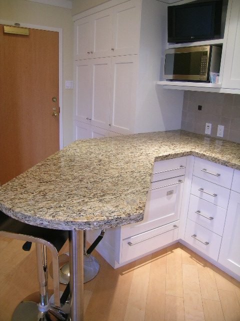 Bright kitchen with granite countertops and white cabinets, hardwood floors. - 902 - 1625 Hornby Street, Vancouver Downtown