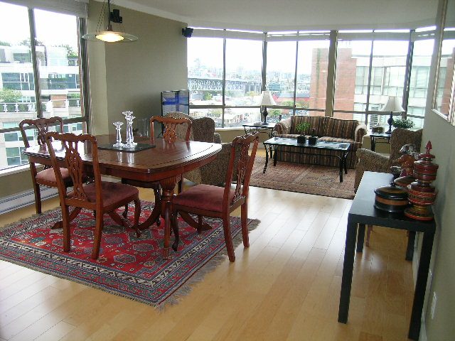 Bright dining room with hardwood floors, city view, and a red rug. - 902 - 1625 Hornby Street, Vancouver Downtown
