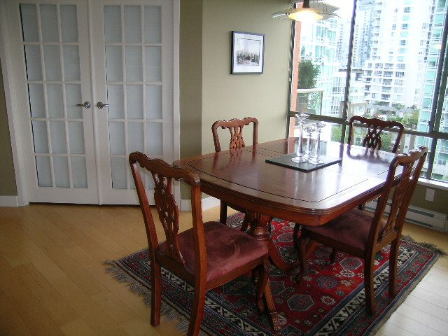 Furnished dining area with hardwood floors, city view, and patterned rug. - 902 - 1625 Hornby Street, Vancouver Downtown