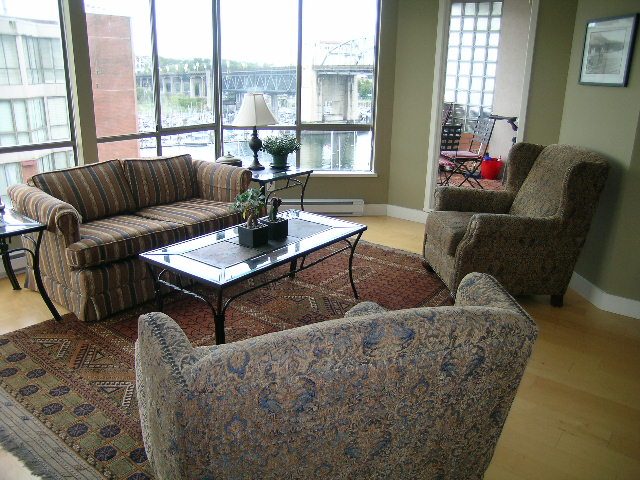 Bright living room with hardwood floors, city view, and patterned furniture. - 902 - 1625 Hornby Street, Vancouver Downtown