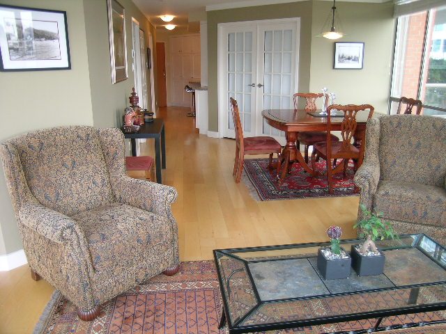 Living room with patterned armchair, hardwood floors, and a glass coffee table. - 902 - 1625 Hornby Street, Vancouver Downtown
