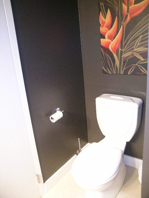 Bathroom with dark walls, white toilet, and floral artwork. - 902 - 1625 Hornby Street, Vancouver Downtown