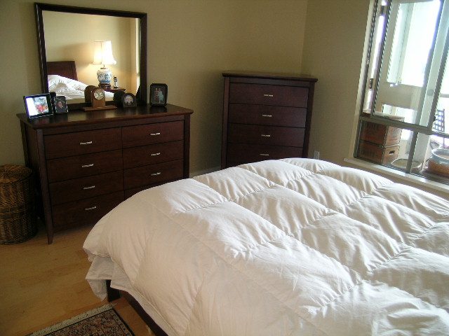 Bright bedroom with wooden furniture, hardwood floors, and a large window view. - 902 - 1625 Hornby Street, Vancouver Downtown