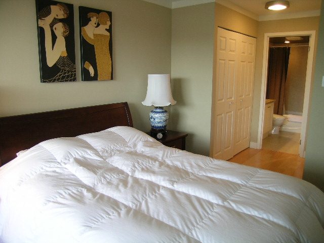 Furnished 1-bedroom + den with white bedding, wooden floors, and artwork on the wall. - 902 - 1625 Hornby Street, Vancouver Downtown