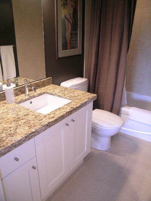Bright bathroom with granite countertops and white cabinetry. - 902 - 1625 Hornby Street, Vancouver Downtown