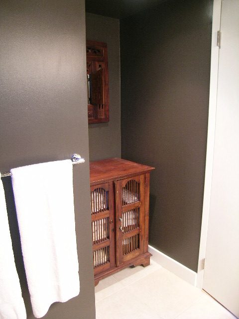 Bathroom with dark walls, wooden cabinet, and white towels. - 902 - 1625 Hornby Street, Vancouver Downtown