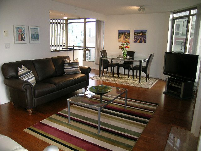 Bright living room with hardwood floors, city view, and modern furniture. - 1701 - 867 Hamilton Street, Vancouver Downtown