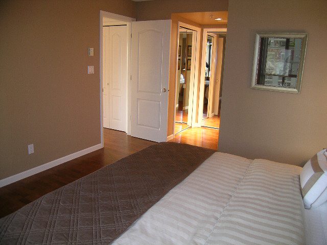 Furnished bedroom with hardwood floors and a mirrored closet door. - 1701 - 867 Hamilton Street, Vancouver Downtown