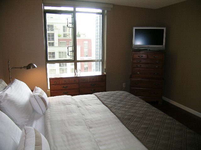 Bright bedroom with two queen beds, large window view, and dresser. - 1701 - 867 Hamilton Street, Vancouver Downtown