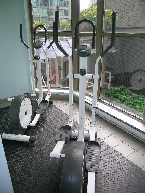 Bright living room with exercise equipment and city view. - 1701 - 867 Hamilton Street, Vancouver Downtown