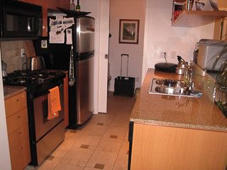 Bright kitchen with granite countertops and hardwood floors, showcasing a cozy and modern living space.