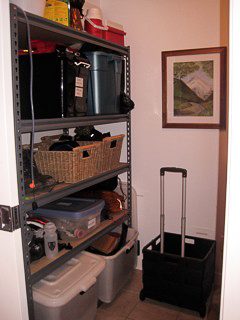 Storage area with shelves holding various items like baskets, coolers, and a suitcase. - 2901-1438 Richards Street, Vancouver Downtown
