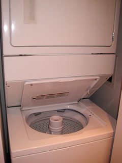 Bright laundry room with stacked washer and dryer, clean white surfaces. - 2901-1438 Richards Street, Vancouver Downtown