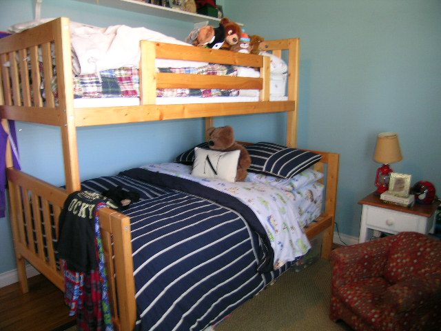 Bright bedroom with bunk beds, striped bedding, and a cozy armchair. - 1332 Camridge Place, West Vancouver