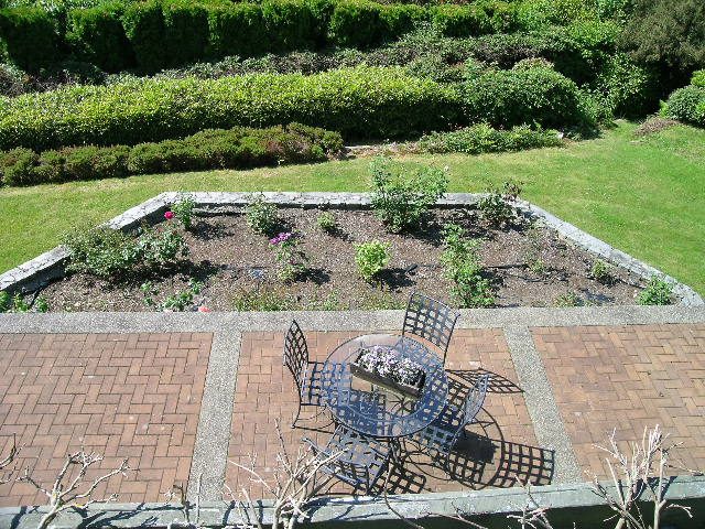 Furnished patio with brick flooring, garden beds, and outdoor seating. - 1332 Camridge Place, West Vancouver