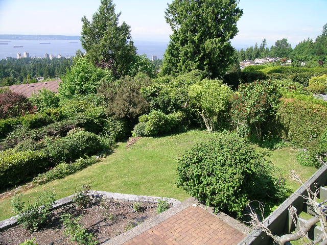 Bright living room with a city view and lush greenery. - 1332 Camridge Place, West Vancouver