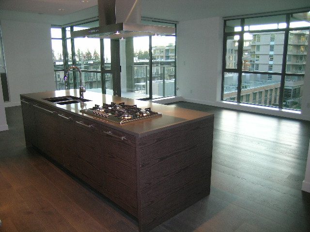 Bright kitchen with modern island, hardwood floors, and city view. - 602 - 5782 Berton Avenue, Vancouver West Side