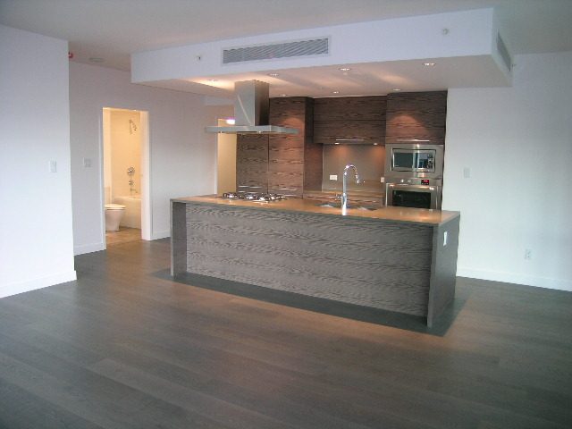 Bright kitchen with modern design, hardwood floors, and a large island. - 602 - 5782 Berton Avenue, Vancouver West Side