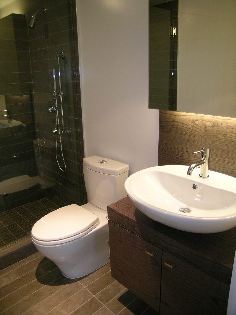 Furnished bathroom with dark wood cabinets, white sink, and modern shower. - 602 - 5782 Berton Avenue, Vancouver West Side