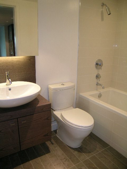 Bright bathroom with modern sink, wooden vanity, and white toilet. - 602 - 5782 Berton Avenue, Vancouver West Side