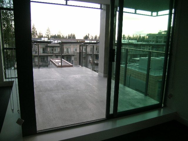 Bright living room with large windows, city view, and modern furnishings. - 602 - 5782 Berton Avenue, Vancouver West Side