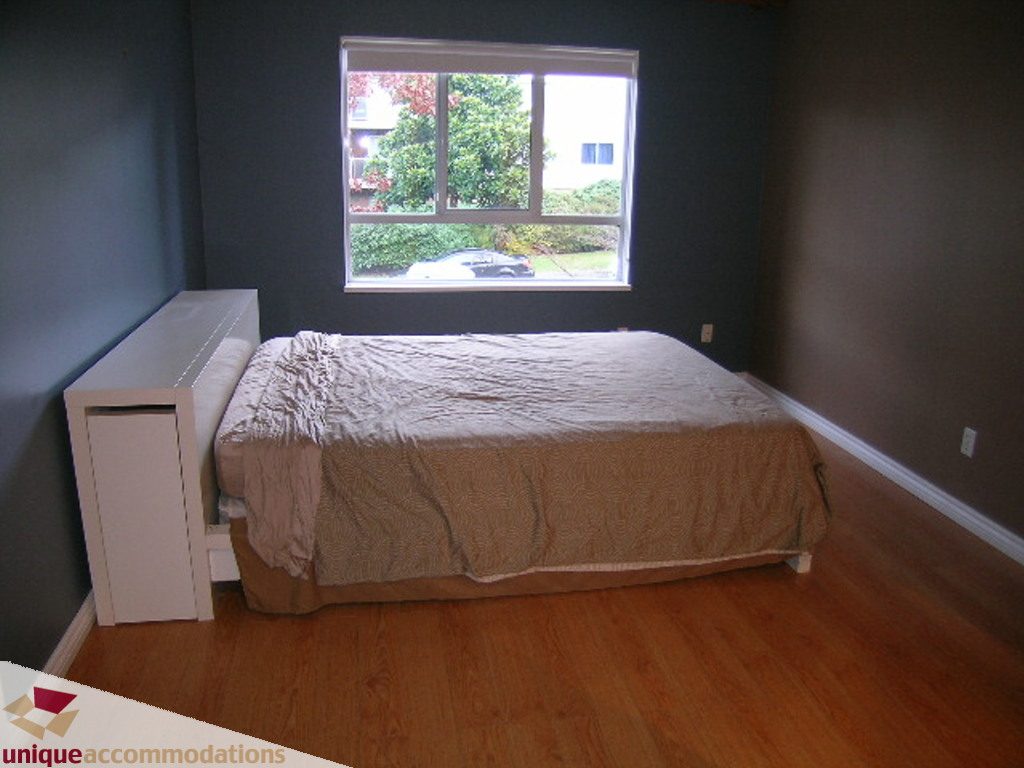 Bright bedroom with hardwood floors and a city view. - 208 - 128 West 8th Street, North Vancouver
