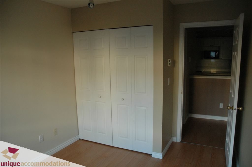 Bright bedroom with closet and hardwood floors. - 208 - 128 West 8th Street, North Vancouver