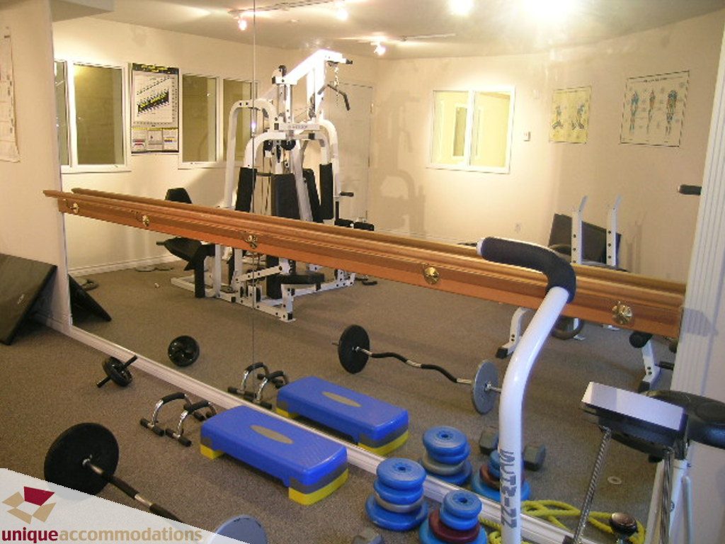 Bright and spacious gym with exercise equipment, mirrors, and weights. - 208 - 128 West 8th Street, North Vancouver