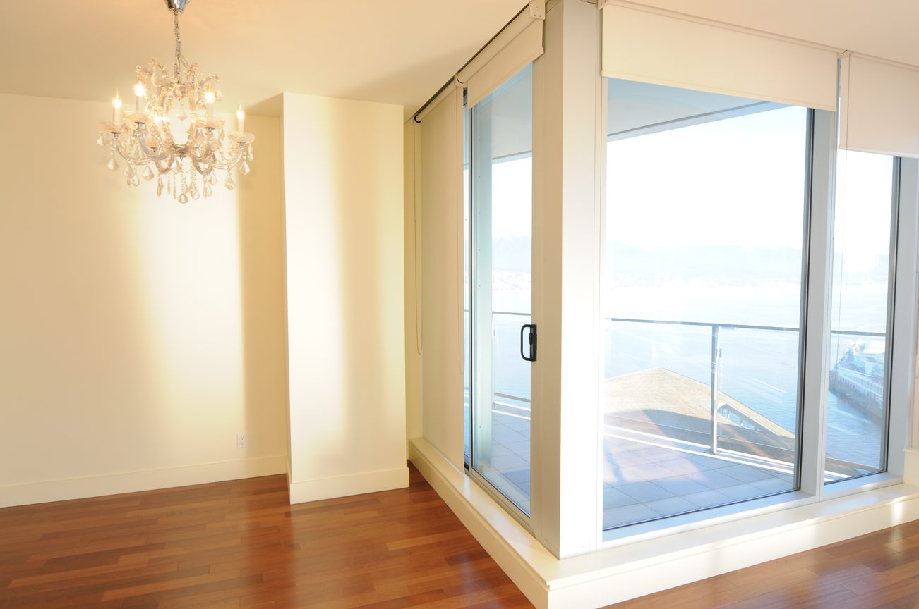 Bright living room with hardwood floors, large windows, and a chandelier. - 2304 - 1077 West Cordova St, Vancouver Downtown
