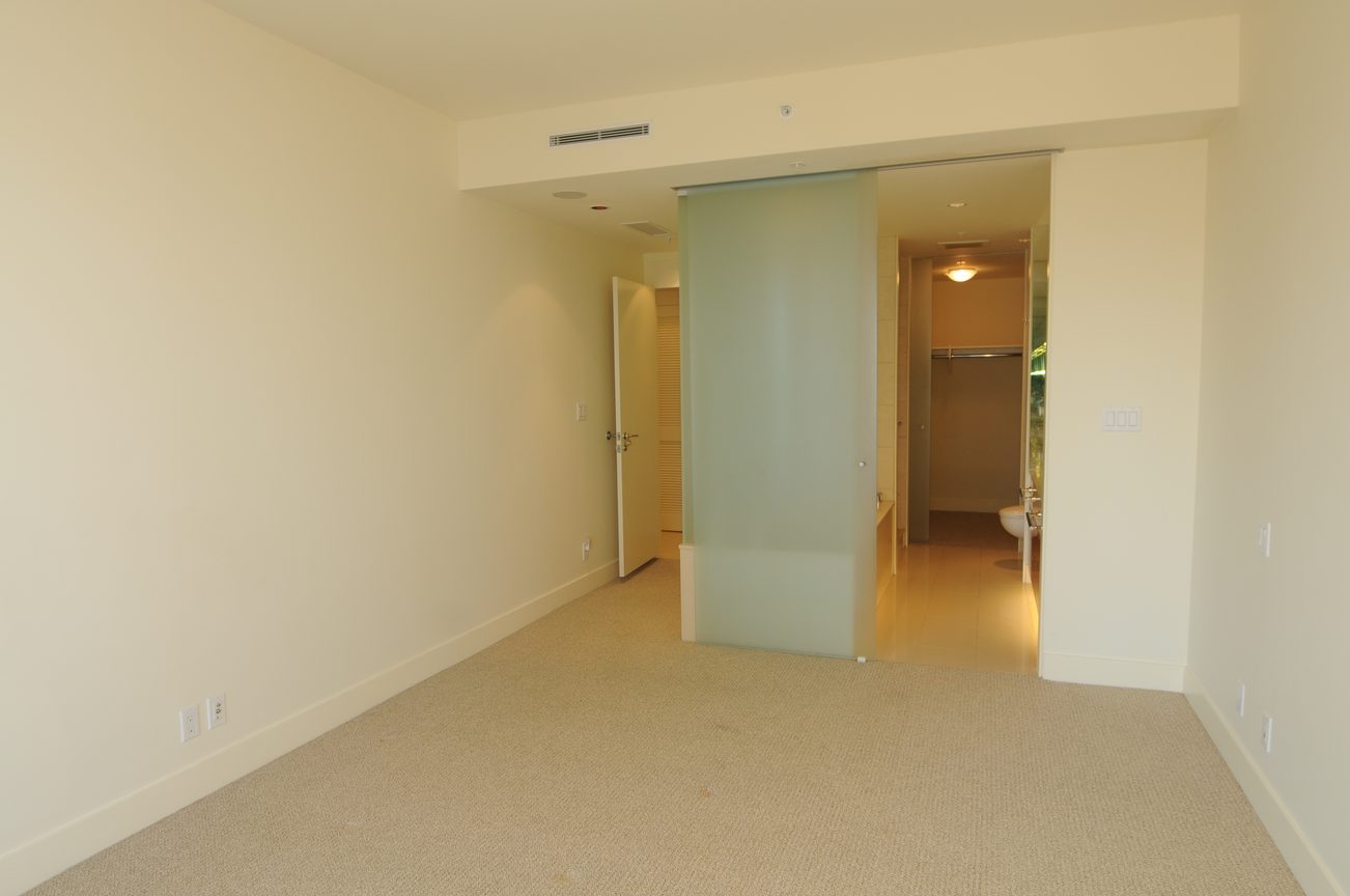 Bright den with sliding glass door leading to bathroom, neutral carpet and walls. - 2304 - 1077 West Cordova St, Vancouver Downtown