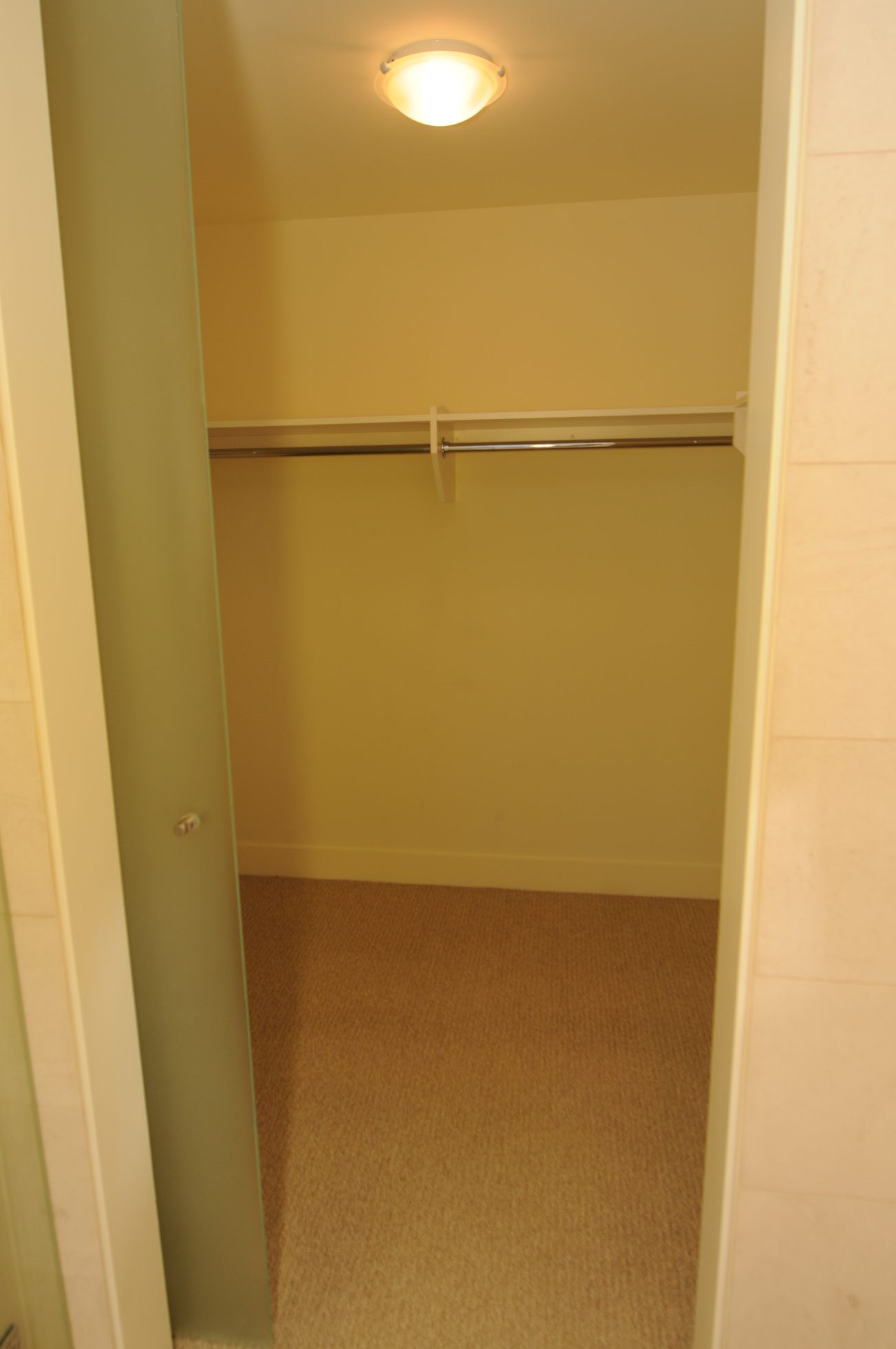 Bright walk-in closet with carpeted floor and a single rod. - 2304 - 1077 West Cordova St, Vancouver Downtown