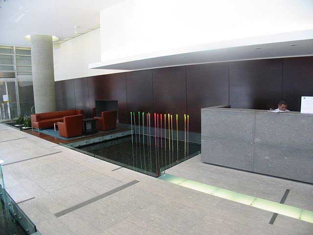 Modern living room with sleek dark walls, glass railings, and ambient lighting. - 2304 - 1077 West Cordova St, Vancouver Downtown